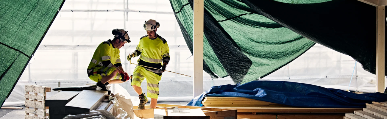 Twee mannen in korte werkbroeken met hi vis elementen 