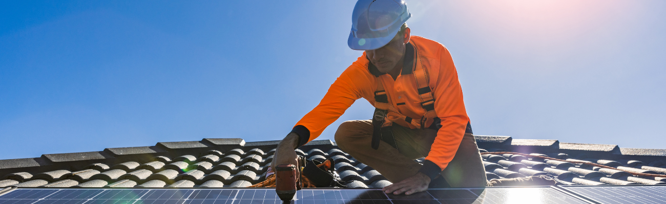 Man in werkkleding installeert zonnepanelen